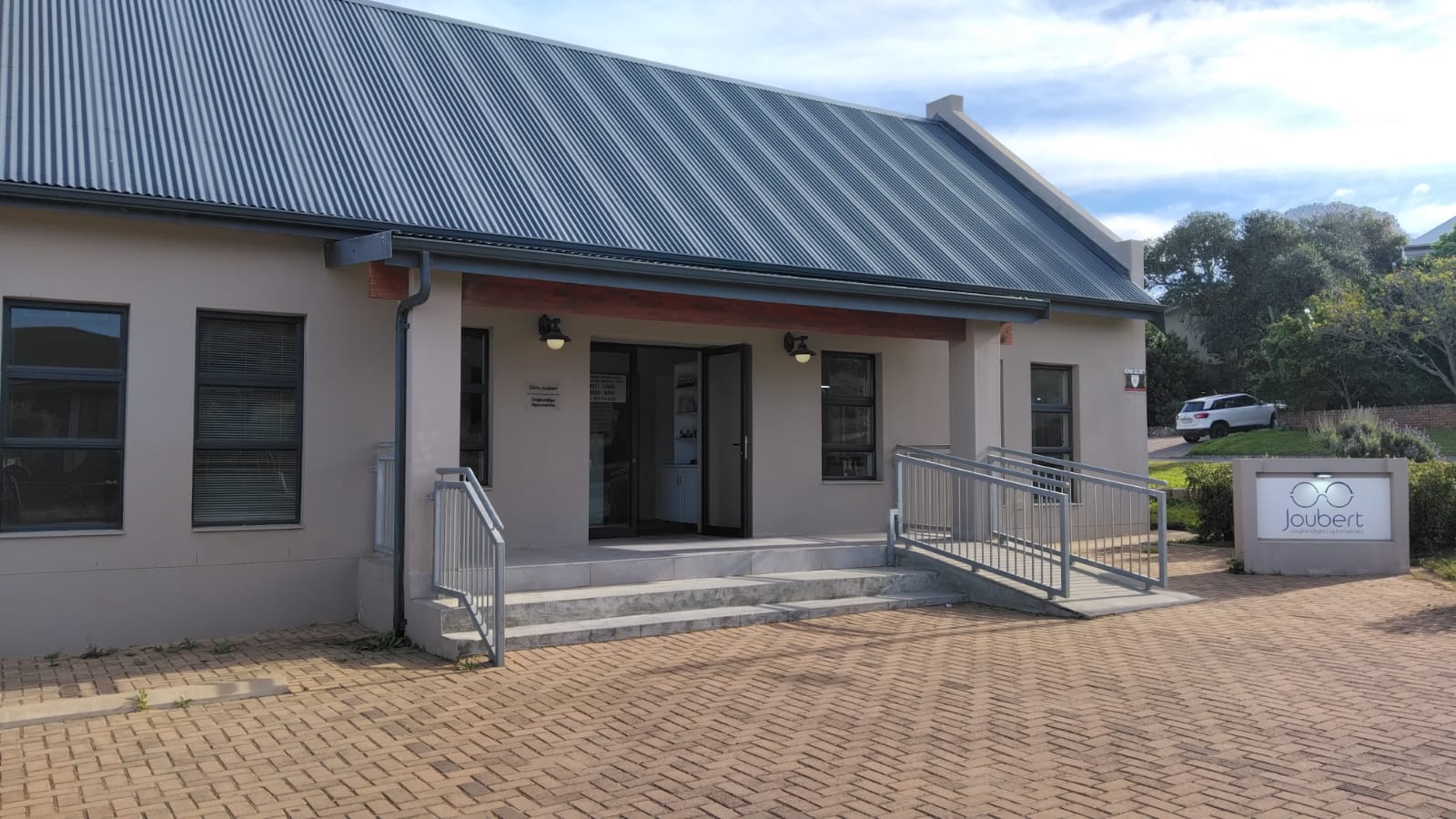 Entrance walkway of the Joubert practice with accessible ramp, stairs and brick paving