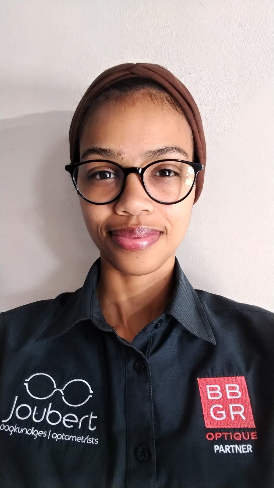 Joubert Optometrists team member in a navy shirt with BBGR optician partner badge