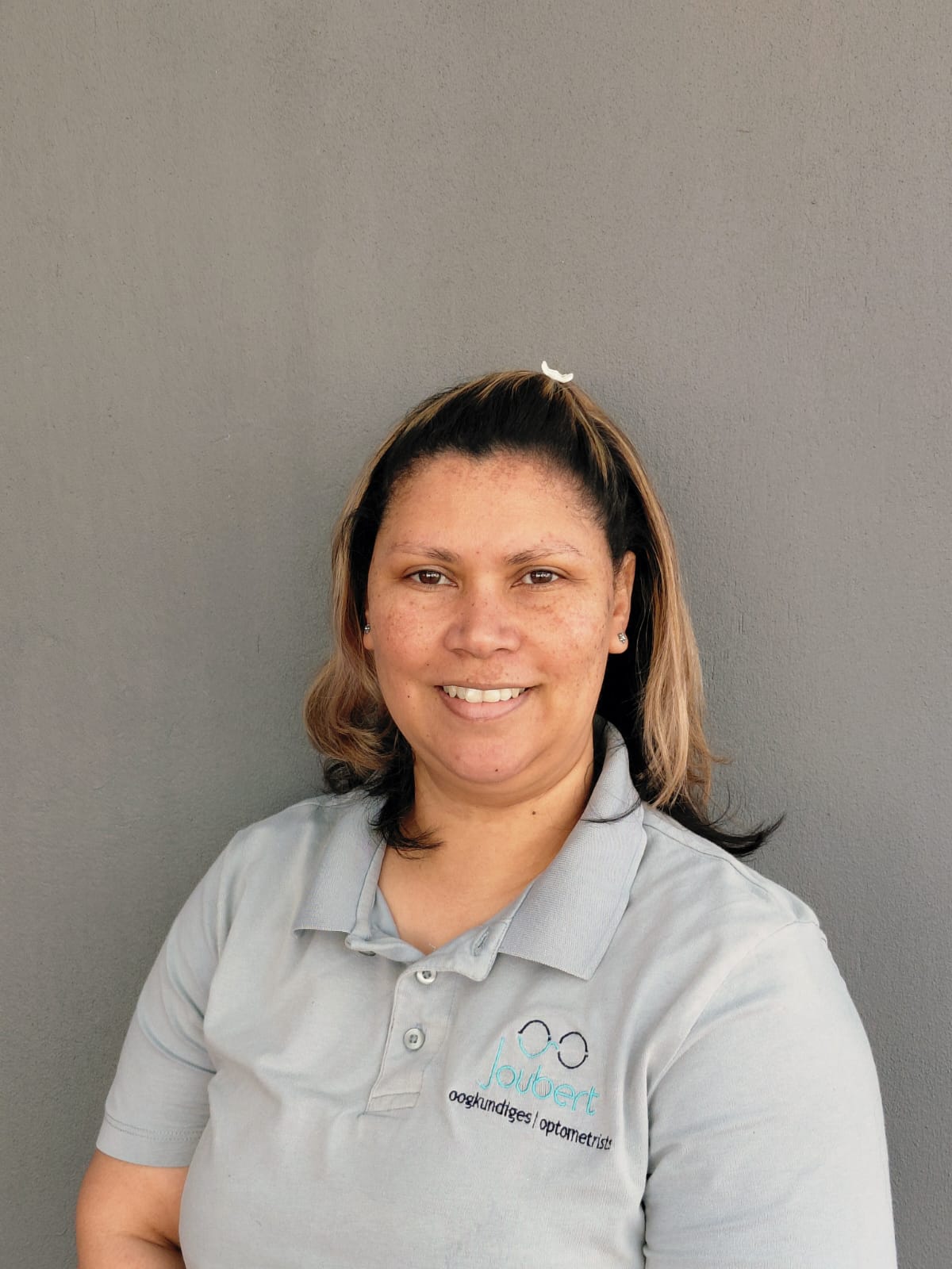 Sharlene — receptionist at Joubert Optometrists in branded polo shirt